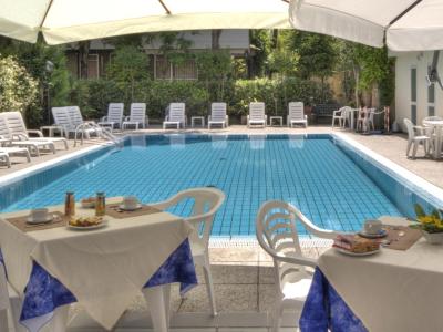 Piscina all'aperto con tavoli apparecchiati per colazione.