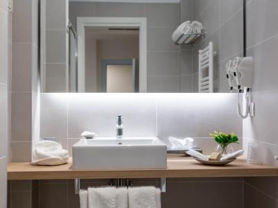 Elegante bagno moderno con lavabo, specchio e asciugacapelli.