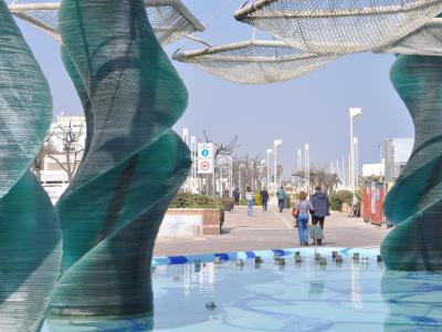 Sculture di vetro su passeggiata, persone passeggiano.