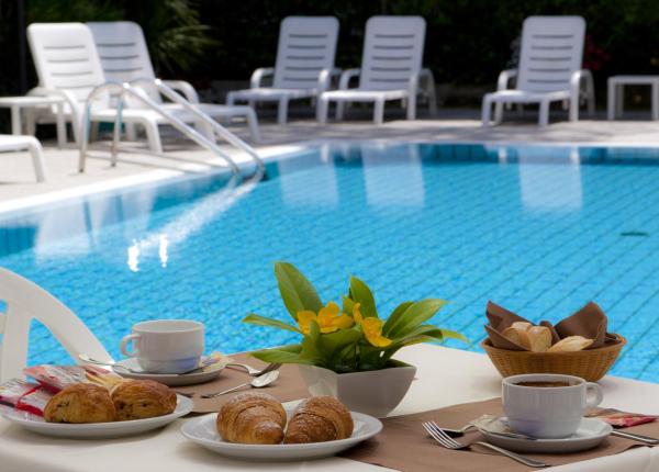 Colazione a bordo piscina con croissant e caffè.