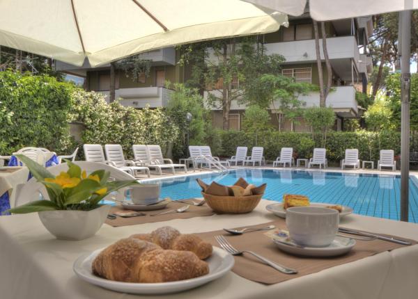 Colazione a bordo piscina con croissant e caffè.