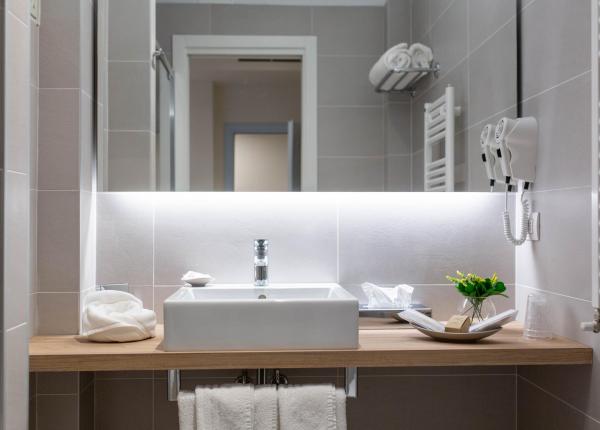 Elegante bagno moderno con lavabo, specchio e asciugacapelli.